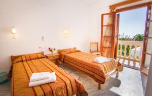 伊奥斯乔拉双子村庄旅馆的酒店客房设有两张床和一个阳台。