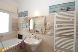 利多迪卡马约雷Il Don Minzoni 98 "Casa Vacanze"的浴室配有盥洗盆、卫生间、浴缸和盥洗盆。