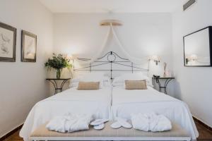 格拉纳达洛斯纳瓦斯宫酒店的一间卧室配有两张床、白色的床单和毛巾。