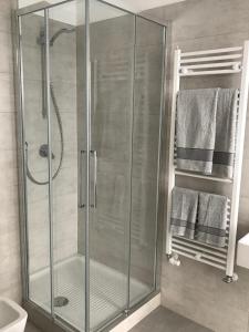 米兰Feel@Home Apartment+Rooms的浴室设有玻璃淋浴间,备有毛巾
