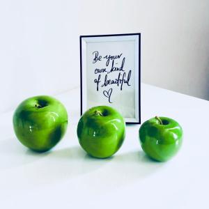 菲林根-施文宁根Boardinghouse BeOne的一张桌子上三颗绿色苹果,上面有照片