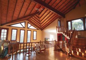 康提中国蒲公英民宿Dandelion Guest house Villa with Mount View的大房间设有木制天花板和楼梯