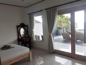 艾湄湾加郎强仁简易别墅的一间卧室设有一张床和一个滑动玻璃门
