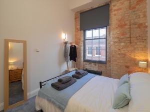 诺丁汉Apartment 16 Broadway House的一间卧室设有一张床和砖墙