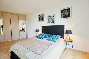 圣布里厄Jean Bart - proximité centre - 2 chambres 90 m2 avec jardin的一间卧室配有一张带蓝色枕头的大床