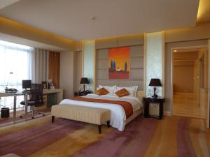 北京北京文津国际酒店的一间卧室配有一张大床、一张桌子和一台电脑