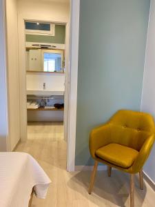 文蒂米利亚Una terrazza sul mare - Balzi Rossi的黄色椅子,位于带浴室的房间里