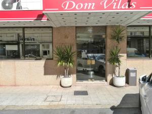 布拉加Hotel Dom Vilas的前面有两棵棕榈树的商店