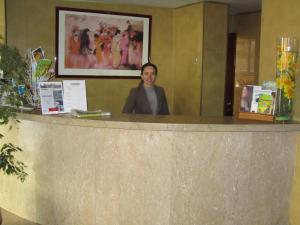 布拉加Hotel Dom Vilas的站在柜台后面的女人