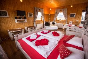 瓦玛里德赫斯塔休闲小屋酒店的一间卧室配有两张带红色枕头的床。