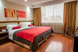 圣地亚哥解放者酒店 的一间卧室配有一张带红色毯子的大床