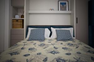 米兰Clever House的一张带两个蓝色和白色枕头的床