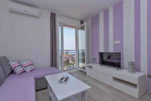 马卡尔斯卡Apartments Nataly with FREE PARKING的客厅配有紫色沙发和电视