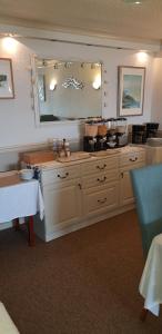 莫克姆货运专线酒店的厨房配有白色橱柜和带镜子的台面