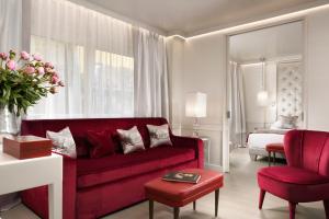 佛罗伦萨朋特维奇欧套房温泉酒店的客厅配有红色的沙发和床。