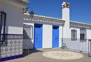 阿尔奇多纳Casa Rural - Santo Domingo Rural的白色的建筑,有蓝色的门和瓷砖