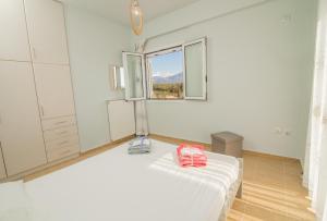 卡拉马塔Elea的白色的卧室设有床和窗户