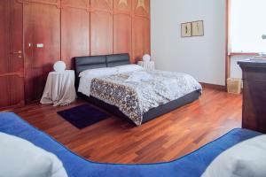 特拉尼Villa Wanda - Residenza di charme的一间卧室配有一张床,铺有木地板
