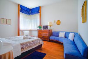 特拉尼Villa Wanda - Residenza di charme的客厅配有蓝色的沙发和床。