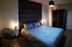 马尔利港Appt 2 pièces à 18 mn du château de Versailles的一间卧室配有一张带蓝色床单的大床和两盏灯。