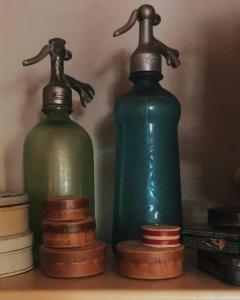 特雷维索La Vigna B&B的两瓶绿色玻璃瓶,放在架子上