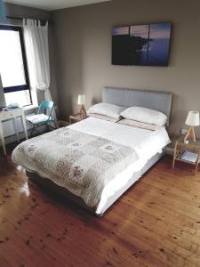 杜林Our View的卧室配有一张白色大床,铺有木地板
