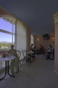 Estepona欧罗巴旅馆的坐在酒店房间桌子上的女人