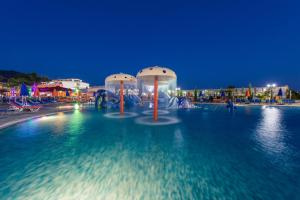 卡拉马孔Caretta Beach Resort & WaterPark的水池,晚上有三个物体