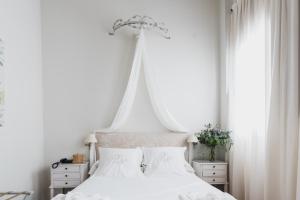 格拉纳达洛斯纳瓦斯宫酒店的白色卧室配有白色床和白色窗帘