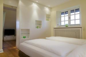 凯图姆Appartementhaus Lüüvhoog的卧室设有两张床、电视和窗户。