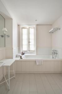 圣马丹德雷Villa Clarisse & Spa by Olivier Claire的白色的浴室设有浴缸和窗户。