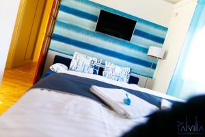 凯奇凯梅特Pál Villa - Premium Apartments - Kecskemét的卧室配有蓝色和白色的床和电视。