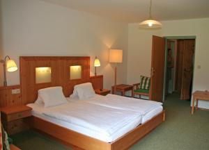 施特罗布尔Hotel Garni Pension zur Wacht的一间卧室配有一张带白色床单的大床