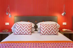 索伦托Casa Dominova de Luxe的一张带两个枕头和红色墙壁的床
