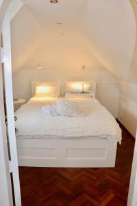 比尔特霍芬Cavalli's Cottage的一张带白色床单和枕头的床