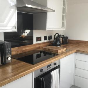 温彻斯特Idyllic Studio Flat的厨房配有白色橱柜和木制台面