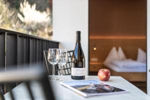 梅拉诺Apartment 39012的一瓶葡萄酒和一张桌子上的苹果