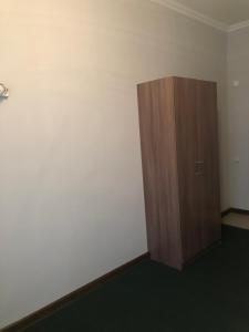 ShetpeMotel “Satti”的一间设有木制橱柜和白色墙壁的客房