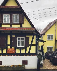 Ingolsheimchez salome et fritz的街上的一座黄色和黑色的房子