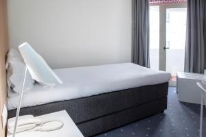 法鲁法鲁中心酒店的酒店客房配有一张床、一张书桌