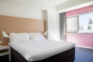 法鲁法鲁中心酒店的一间设有大床和窗户的酒店客房