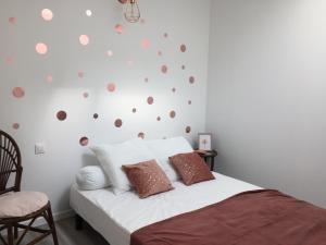 阿宰勒里多le gite de Jules的一间卧室配有一张带波卡圆点墙壁的床