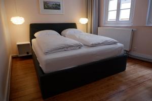 蒂宾根Apartment Zentral的卧室内的一张带白色床单和枕头的床