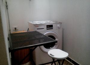 拉斯加莱塔斯A cozy flat in the heart of El Fraile的小房间设有洗衣机和凳子