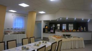 捷克布杰约维采Hotel Metropol CB的餐厅设有2张桌子和椅子,提供食物