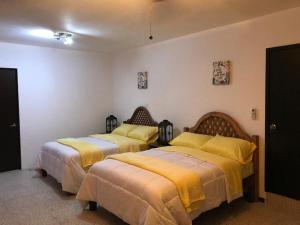 巴耶斯城Apartamento&Habitación Galeana的黄色毯子的客房内的两张床