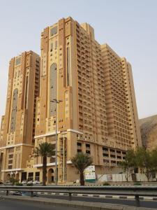 麦加Altelal Apartment的一座大型公寓楼,前面有棕榈树