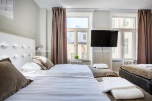 哥德堡City Hotell Avenyn的一间卧室配有两张床和一台平面电视