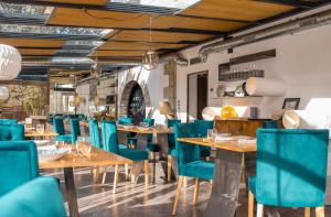 Collado Mediano拉驼蕾盒子艺术酒店的餐厅设有木桌和蓝色椅子