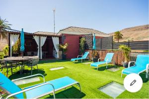 阿古伊梅斯Casa Roque Aguayro的庭院设有蓝色的椅子、桌子和草地